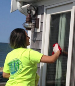 A woman in yellow shirt cleaning window.