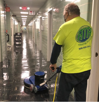 A man in yellow shirt cleaning the floor.