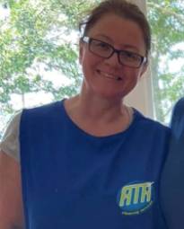 A woman wearing glasses and a blue shirt.