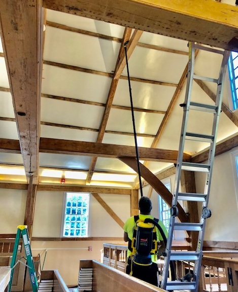 A man is on the ladder in an attic.